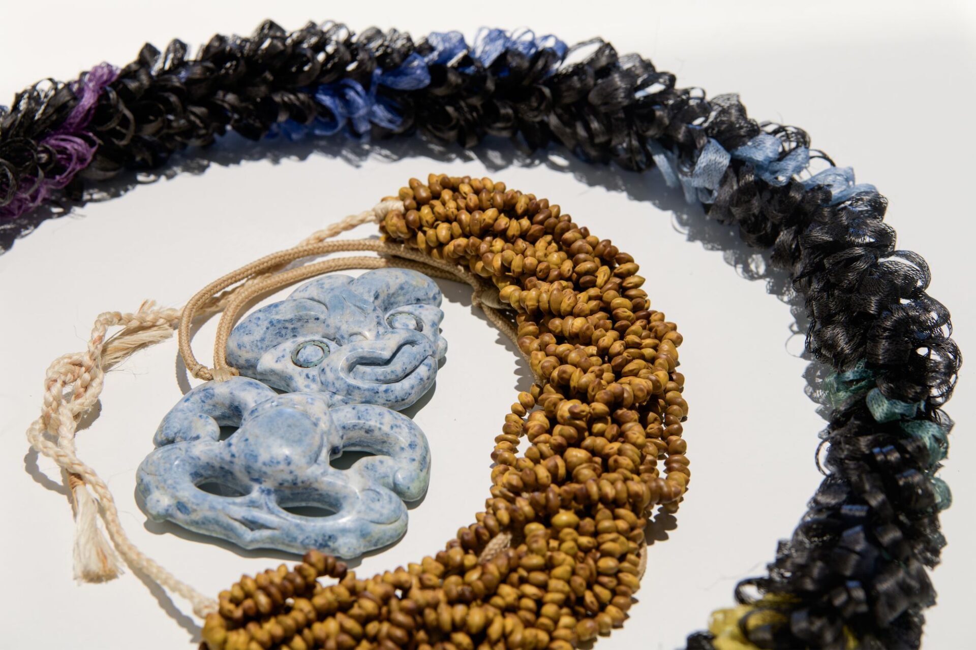 Isaac Te Awa - Hei houhi, Houhi, whītau, tae, Ereni Pūtere - Te Taura Tākata, he hei kano kōwhai, Kano kōwhai, muka, aho, Fayne Robinson - Tiki Aotea, Aotea pounamu, pāua, taura iwituna. 'Āhuataka: A Wānaka of Kāi Tāhu Woven Adornment', Photo Credit Owen Spargo